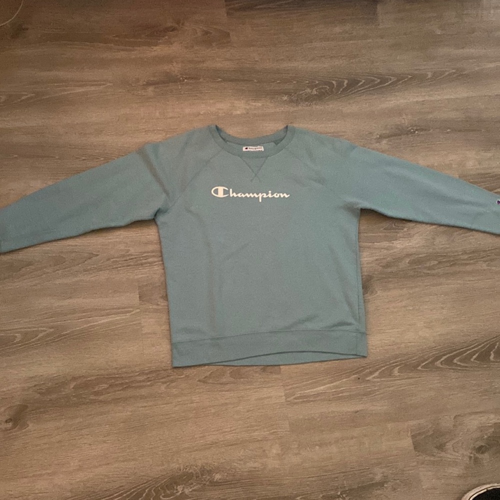 Light blue almost teal sweatshirt with white writing. Size fits medium or large